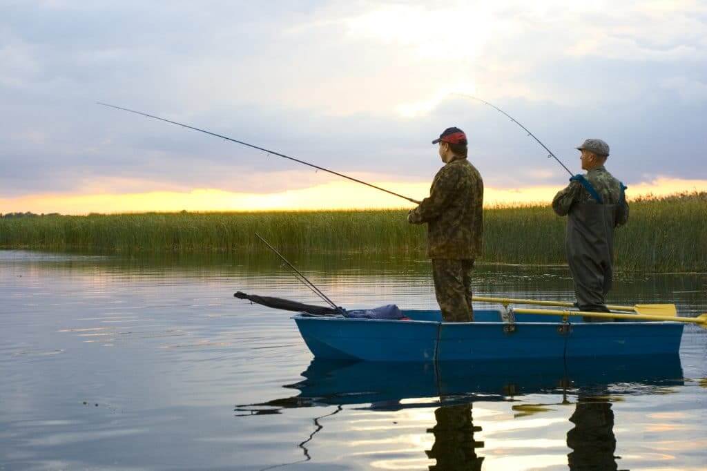 Two fishermans on boat. catching pike