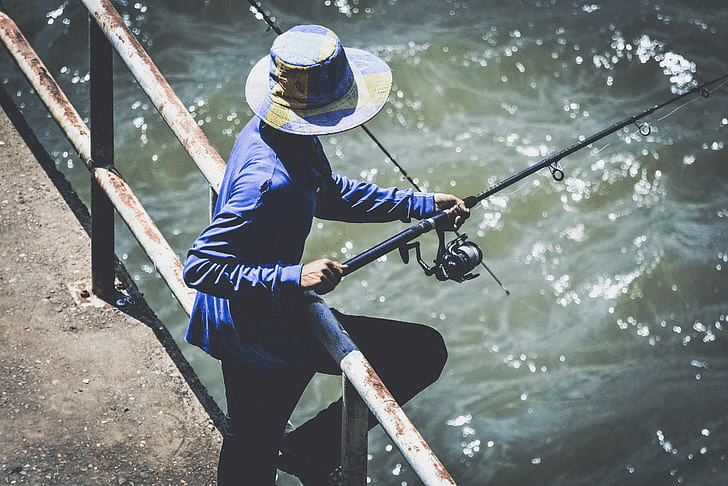 Man fishing from a bridge with a travel rod