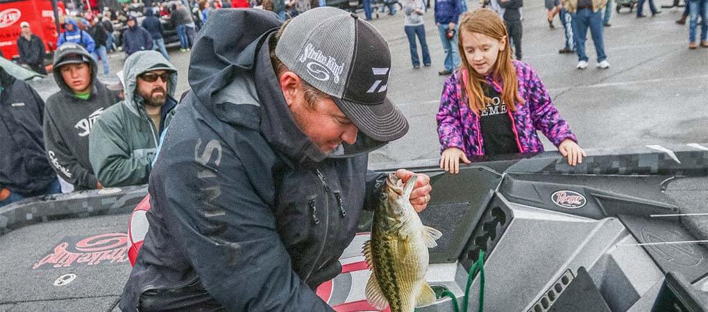 Cody Meyer pulled a spotted bass out of his live well during an FLW tournament as fans looked on