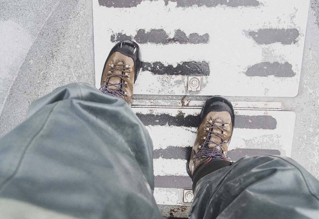 man looking down at his fishing waders