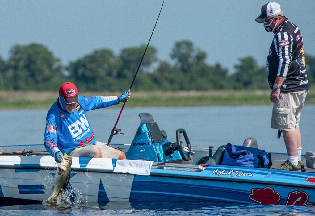 Mark Davis lands a big bass in a Bass Pro Tour tournament  as his boat official looks on (photo by Garrick Dixon/Major League Fishing)