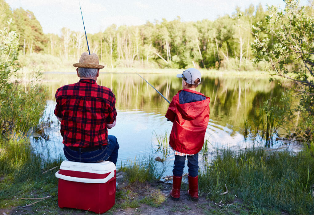 grandfather and grandson fishing on a lake