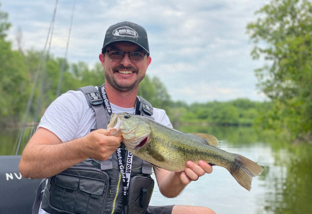 Wesley Littlefield, Angler's contributing author fishing for bass, wearing a PFD