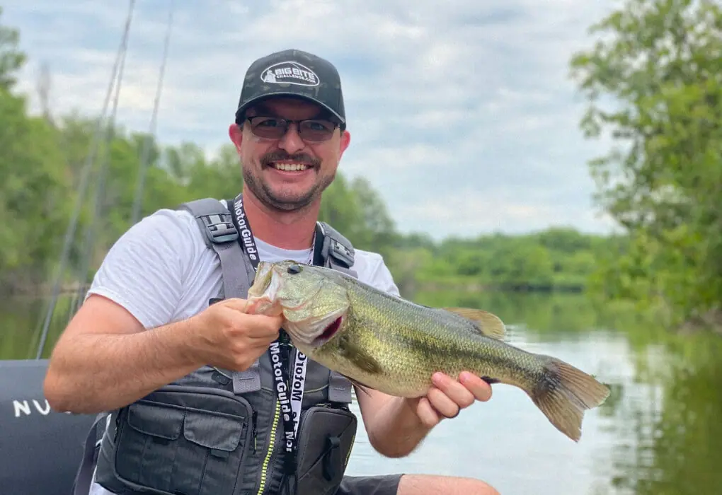 Wesley Littlefield, Angler's contributing author fishing for bass, wearing a PFD