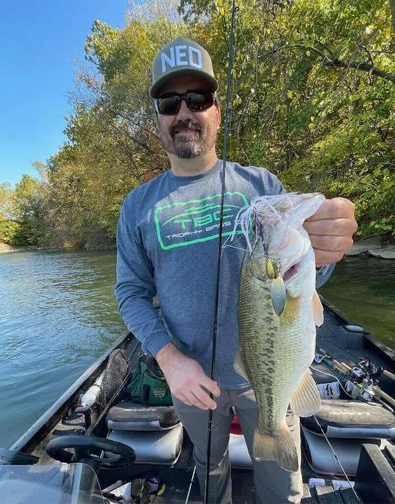 Travis Perret displayed one of many bass he and a partner caught on spinnerbaits on a windy fall day (Photo by Brent Frazee)