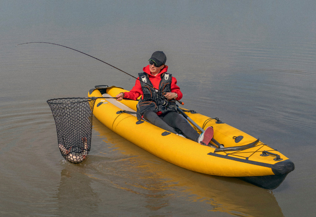 fisherwoman out on water, caught bass with the help of the fishing net