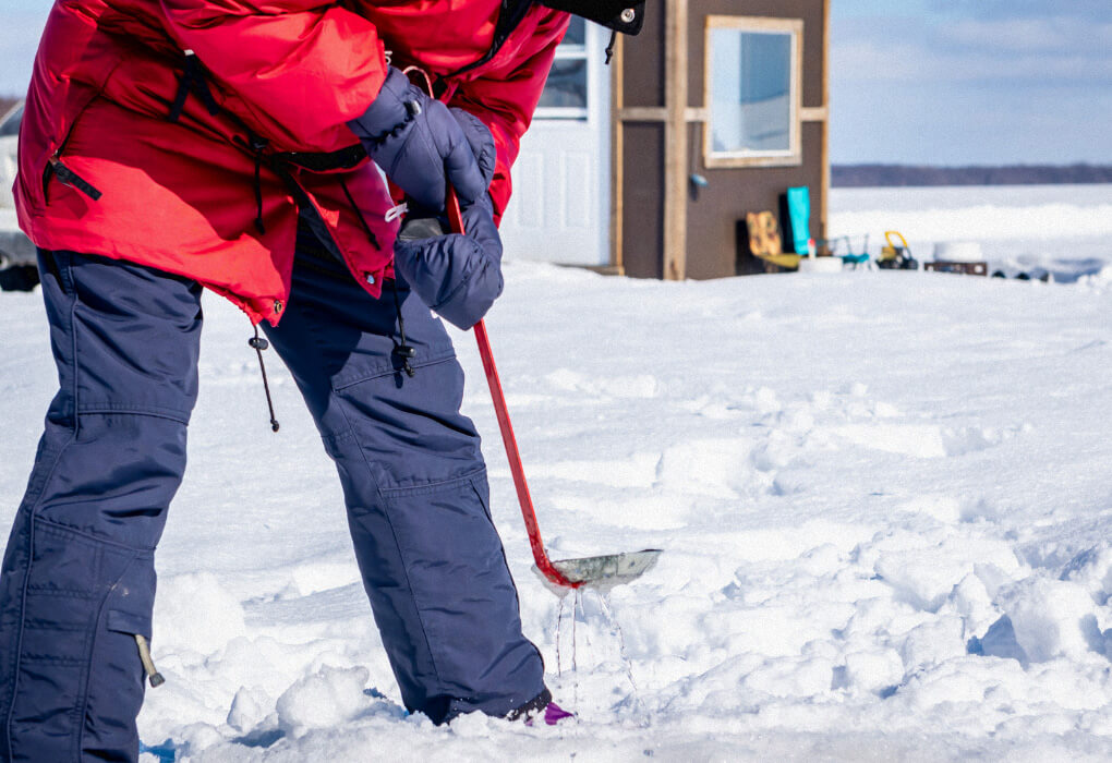 ice fishing gloves worn by a fisherwoman out on ice