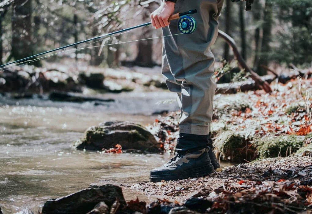 fly fishing angler on shore, wearing fishing shoes